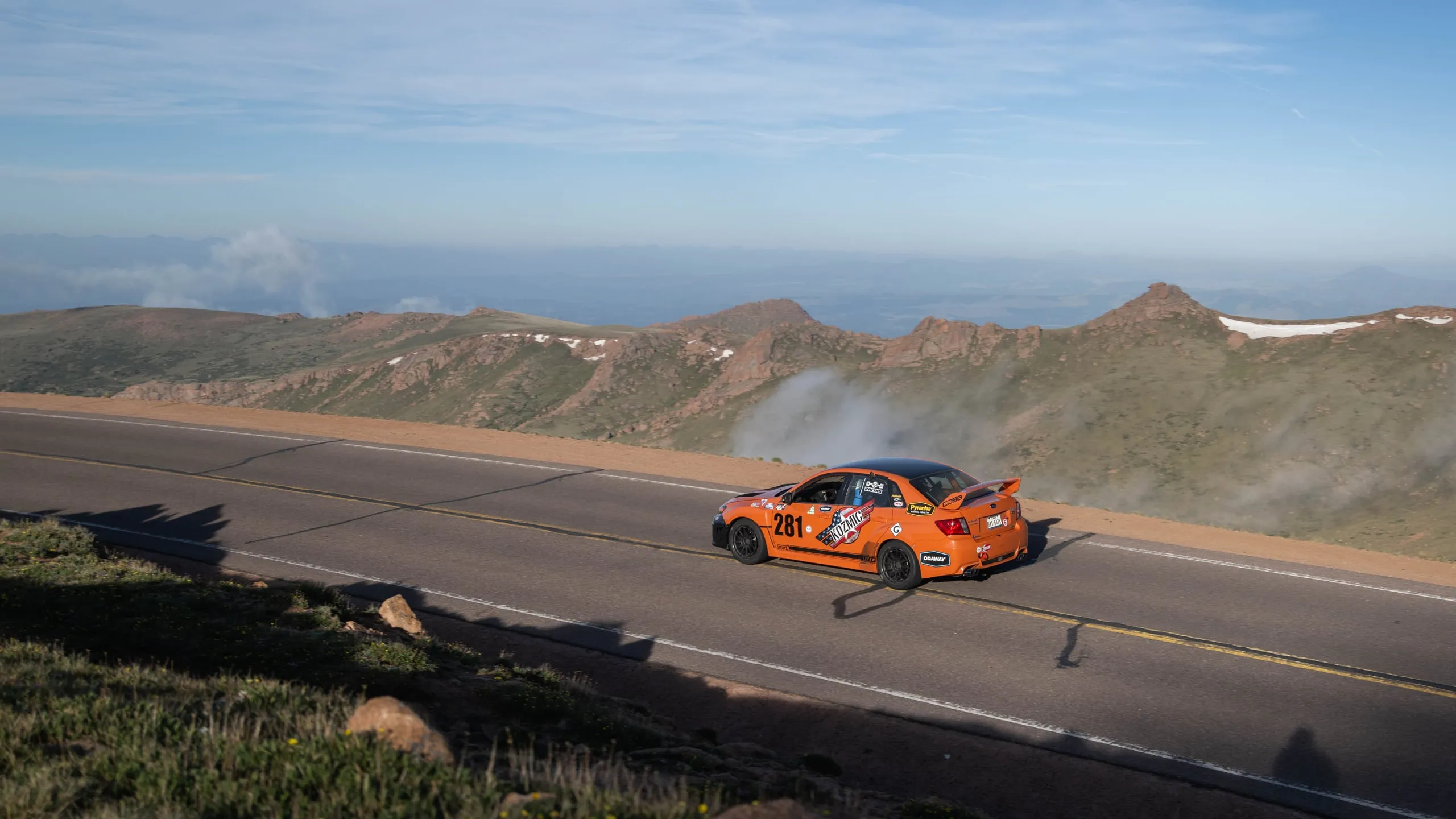 Sober Racing’s orange number 281 Subaru on the Pikes Peak summit ridge, with clouds below